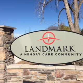 A sign for Landmark, A Memory Care Community, set against a stone wall.