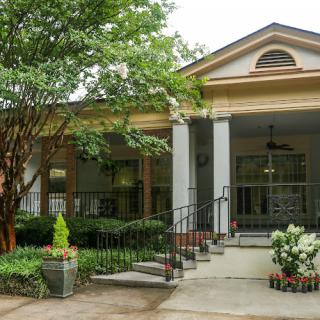 A beautiful residential house with a welcoming porch and landscaped front yard.