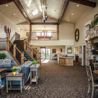 A spacious living area with a modern design featuring a staircase and fireplace.