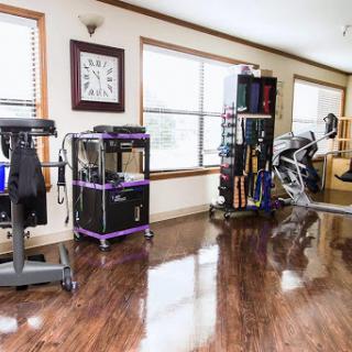 A well-equipped home gym featuring various fitness equipment and ample natural light.
