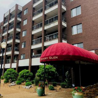 A residential apartment building with a red awning entrance.