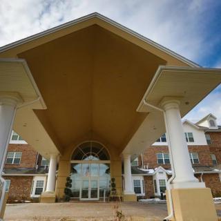 A grand entrance to a building with prominent columns and large glass doors.