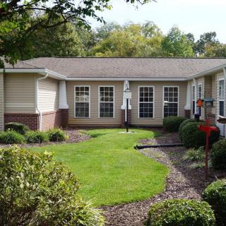 A well-maintained garden with a central lawn surrounded by a residential building.