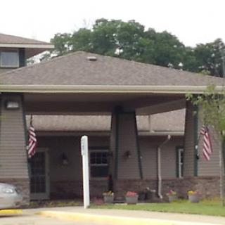 A welcoming entrance to a residential building with flags displayed.