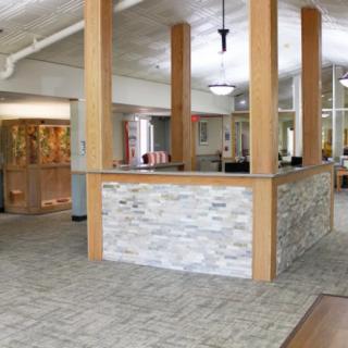 A modern office reception area with a stone wall and open layout.