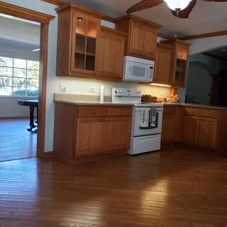 A kitchen with wooden cabinets and a hardwood floor.