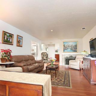 A cozy living room with comfortable seating, a large television, and decorative artwork on the walls.