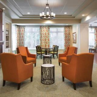 A cozy lounge area with orange chairs and modern decor.