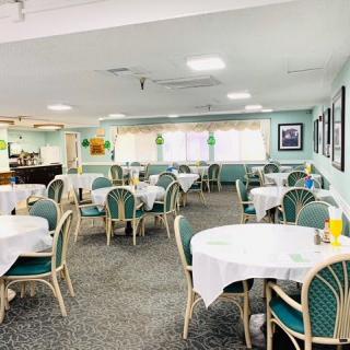 A spacious dining area with neatly arranged tables and chairs in a well-lit restaurant.