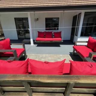 A cozy outdoor patio with red-cushioned wooden seating, perfect for relaxation.