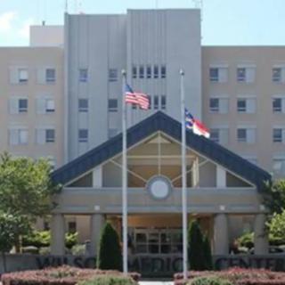 A hospital building with prominent entrance and flagpoles out front.