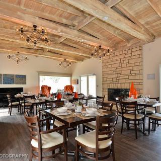 A cozy restaurant dining area with wooden ceilings and elegant chandeliers.