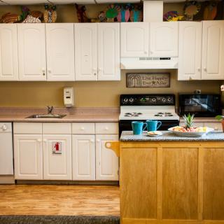 A well-equipped kitchen featuring white cabinets, a stove, and a microwave.
