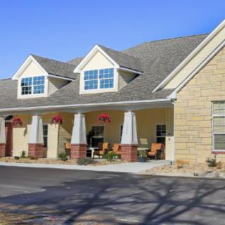 A suburban residential building with a gable roof and front porch.