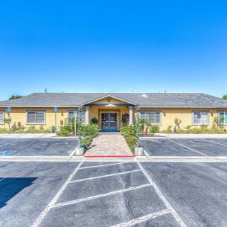 A single-story building with a parking lot and landscaped pathway leading to the entrance.