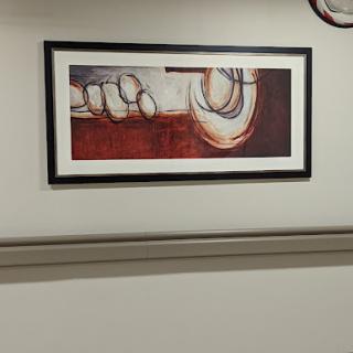 An abstract painting framed and displayed on a wall.