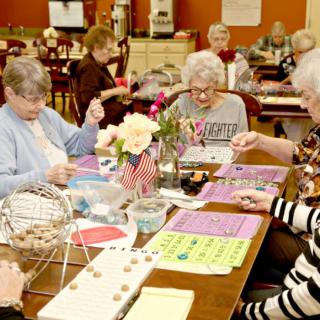 A group of seniors playing bingo together in a community center setting.