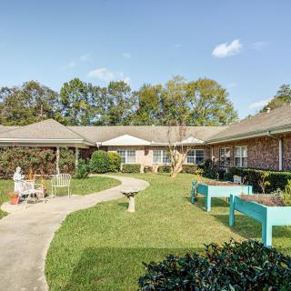 A well-maintained courtyard garden with a walkway and seating area surrounded by buildings.
