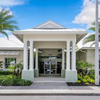 A resort entrance with tropical landscaping and clear blue skies.