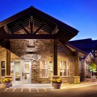 A well-lit building entrance with a stone facade during twilight.
