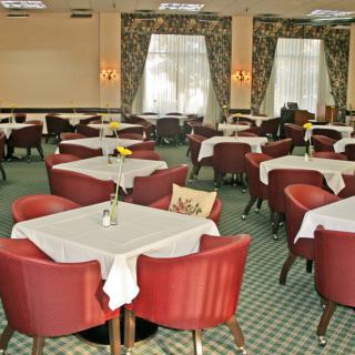 An elegantly arranged restaurant dining room with neatly set tables and comfortable chairs.