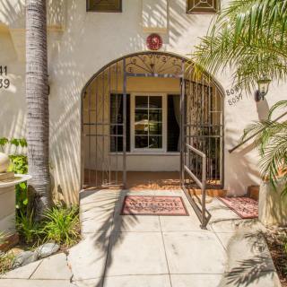 A sunlit entrance with an archway surrounded by palm trees.