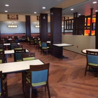 An empty restaurant dining area with neatly arranged tables and chairs.