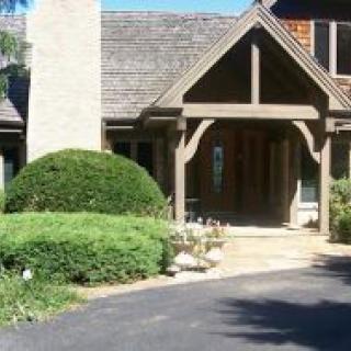 A beautiful house entrance with a garden and driveway.