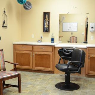 A view of a hair salon featuring a styling chair and waiting area.