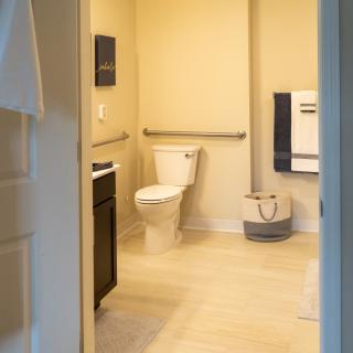 A modern bathroom with a toilet, sink, and towel rack.
