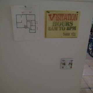 Wall with a fire escape floor plan and warning sign.