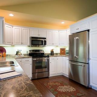 A modern kitchen with stainless steel appliances and white cabinetry.