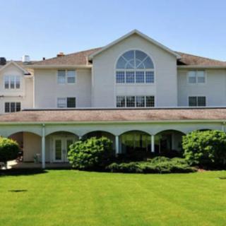 A large residential building with a well-maintained lawn and greenery.
