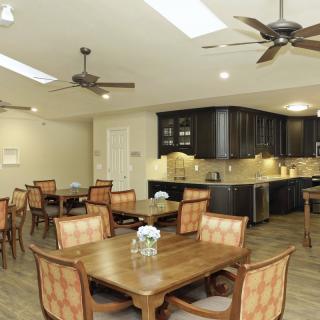 A modern kitchen and dining area with wooden furniture and ceiling fans.