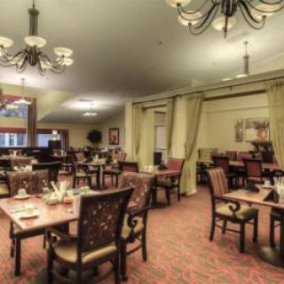A spacious dining room with elegant furnishings and chandeliers.