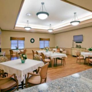 A well-lit dining room with neatly arranged tables and chairs.