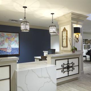 A beautifully designed hotel lobby featuring a modern reception desk with elegant lighting and artwork.