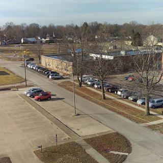 A panoramic view of a parking lot and surrounding urban area on a clear day.