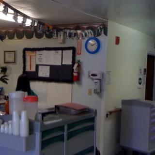A decorated reception desk area with a notice board, clock, and office supplies.