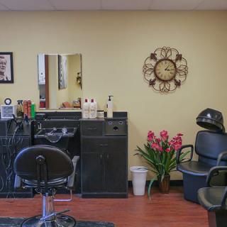 Interior of a hair salon with styling stations, chairs, and decor.
