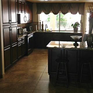 Spacious kitchen with dark cabinets and a large window view.