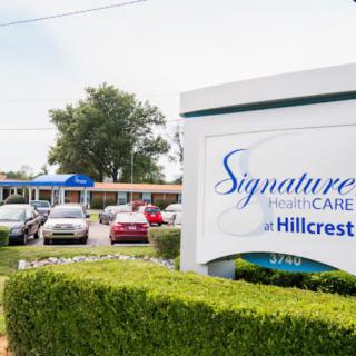 The entrance of Signature HealthCARE at Hillcrest features a prominent sign and parking area.