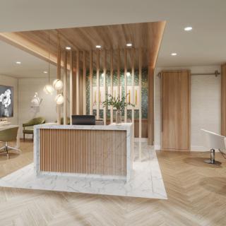 A modern reception area with wood accents and a marble desk, featuring contemporary lighting and neutral tones.