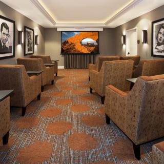 Cozy theater room with comfortable seating and a large projector screen.