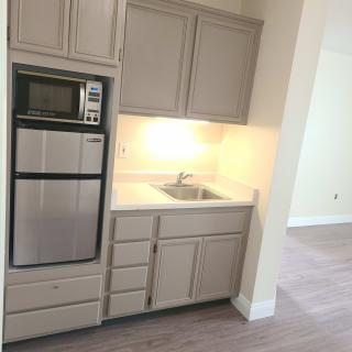 A modern kitchen area with cabinets, an oven, and a sink.