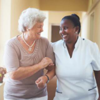 A nurse providing support to a senior woman in a healthcare setting.