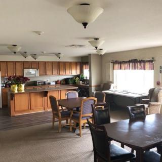 A spacious kitchen and dining area with wooden furniture and ample lighting.