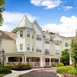 A picturesque residential building under a blue sky with clouds.