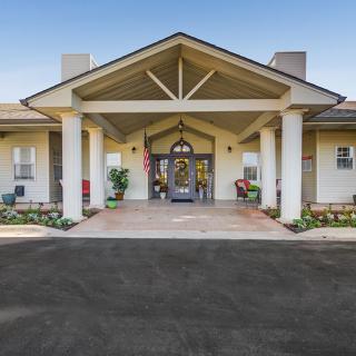 A welcoming building entrance with columns and landscaping.