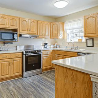 A modern kitchen with wooden cabinets and stainless steel appliances.